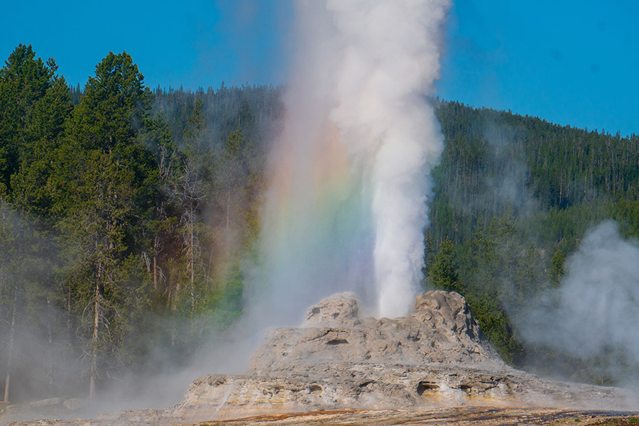 Steam rising from geothermal hot springs and mineral terraces